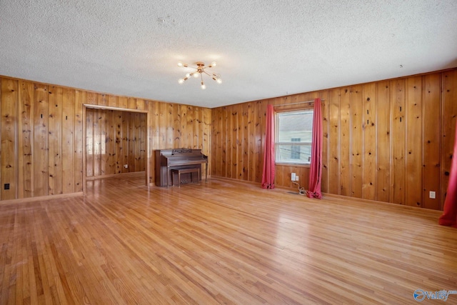 unfurnished living room featuring a textured ceiling and wood finished floors