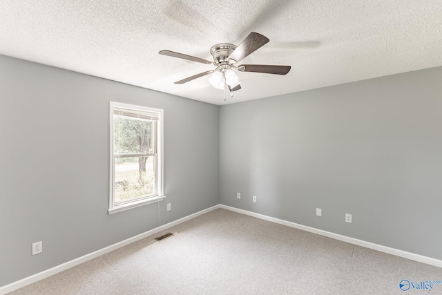 carpeted spare room featuring a textured ceiling and ceiling fan