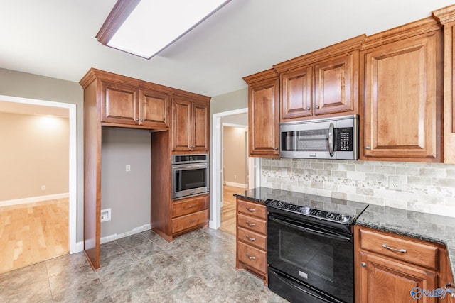 kitchen featuring dark stone counters, stainless steel appliances, light hardwood / wood-style floors, and tasteful backsplash