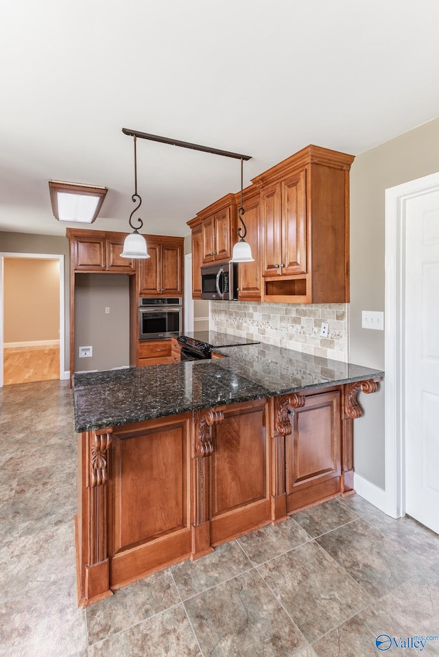 kitchen featuring appliances with stainless steel finishes, dark stone counters, kitchen peninsula, decorative light fixtures, and tile patterned floors