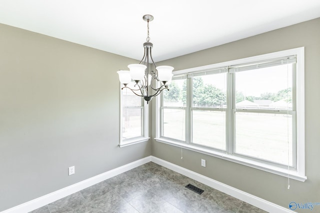 unfurnished room with an inviting chandelier and tile patterned flooring