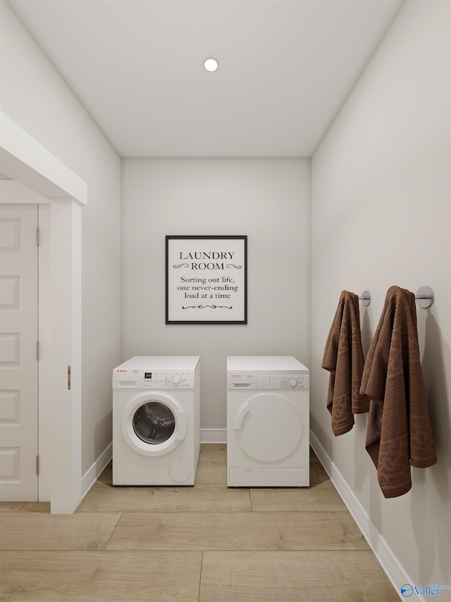 laundry area with separate washer and dryer and light hardwood / wood-style flooring