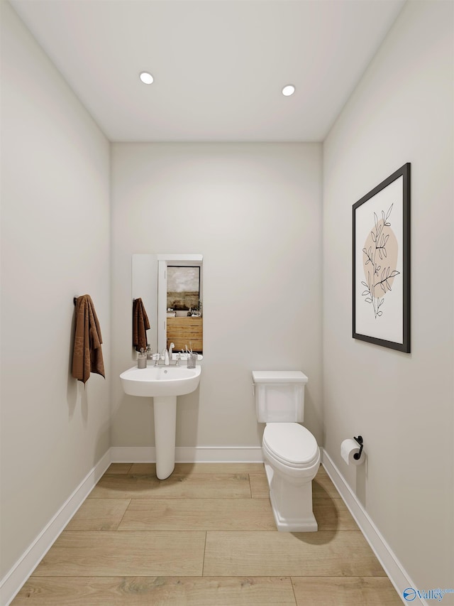 bathroom featuring wood-type flooring and toilet