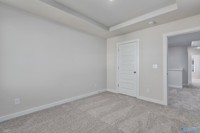 unfurnished bedroom featuring carpet flooring and a raised ceiling