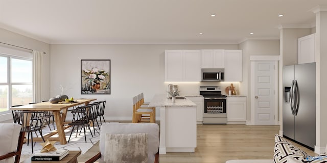 kitchen with light stone counters, stainless steel appliances, sink, and white cabinets