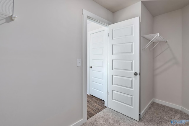 spacious closet with dark colored carpet