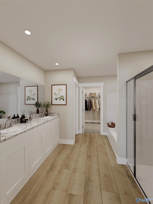 bathroom featuring walk in shower, vanity, and hardwood / wood-style floors