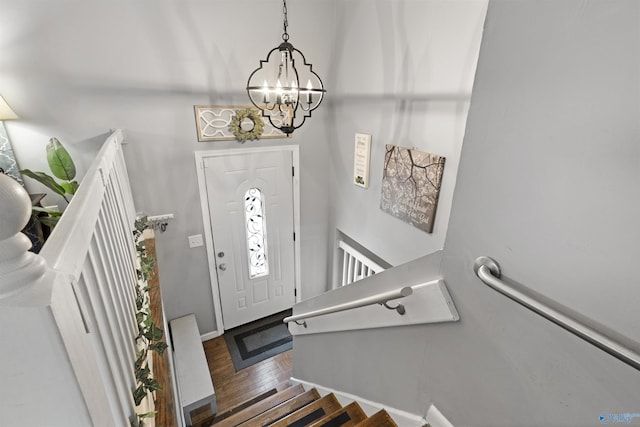 entryway featuring stairway, baseboards, an inviting chandelier, and wood finished floors