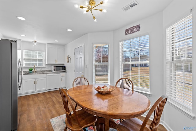 dining space with light wood-type flooring, visible vents, recessed lighting, an inviting chandelier, and baseboards