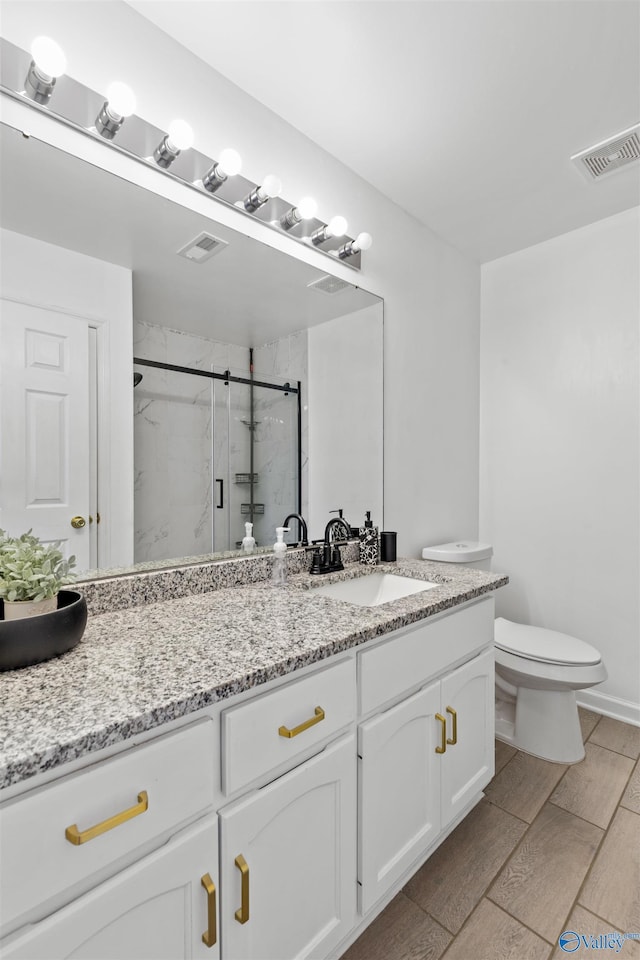 full bathroom with visible vents, toilet, a stall shower, and vanity