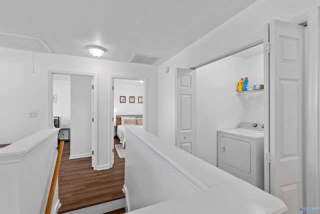 corridor with baseboards, visible vents, dark wood finished floors, attic access, and washer / clothes dryer