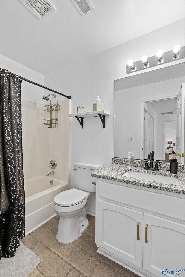 full bath with visible vents, toilet, wood finished floors, and vanity