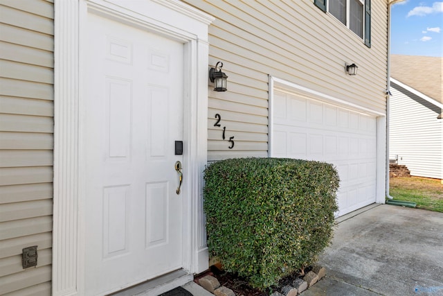 entrance to property featuring driveway and an attached garage