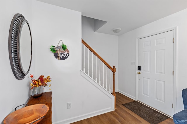 foyer entrance featuring stairs, wood finished floors, and baseboards