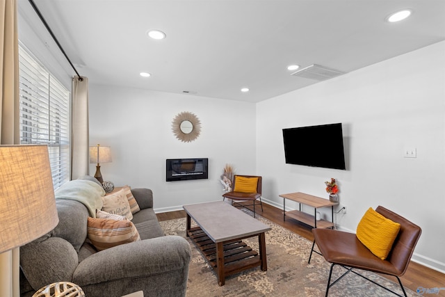 living area featuring visible vents, recessed lighting, baseboards, and wood finished floors