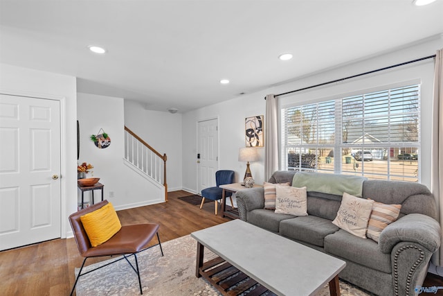 living area with recessed lighting, stairs, baseboards, and wood finished floors