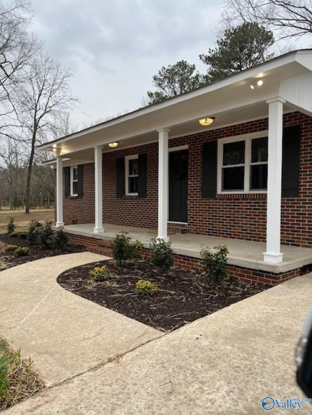 view of front facade featuring covered porch and brick siding