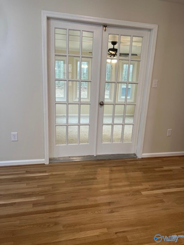 entryway featuring baseboards, wood finished floors, and a ceiling fan