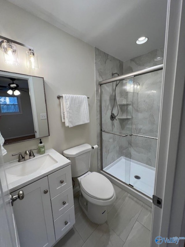 bathroom featuring marble finish floor, toilet, vanity, and a shower stall