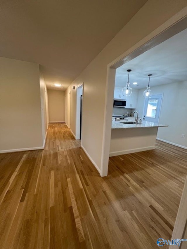 hall with baseboards and wood finished floors
