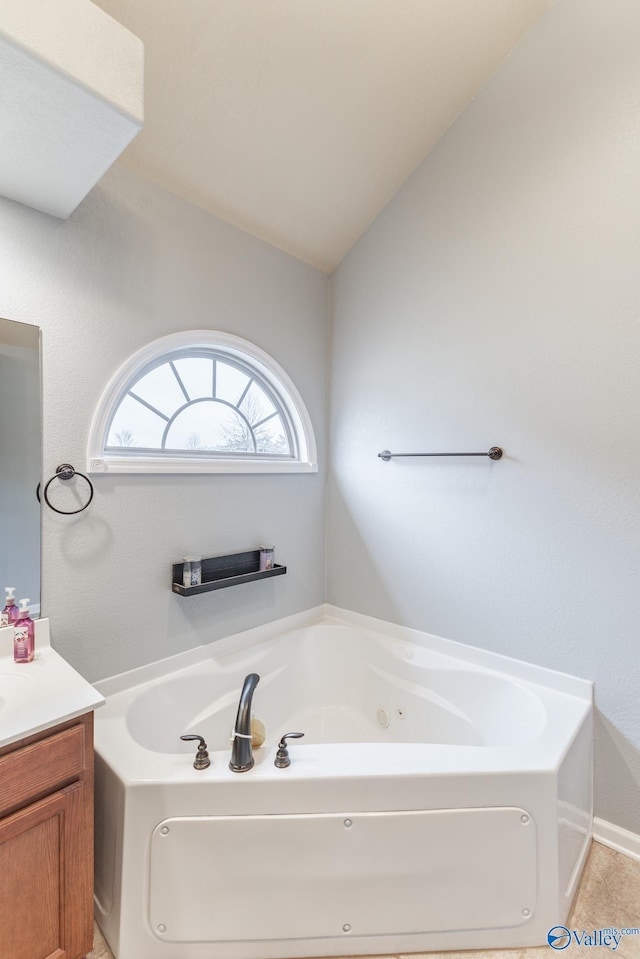 bathroom featuring a bathing tub, vanity, and lofted ceiling