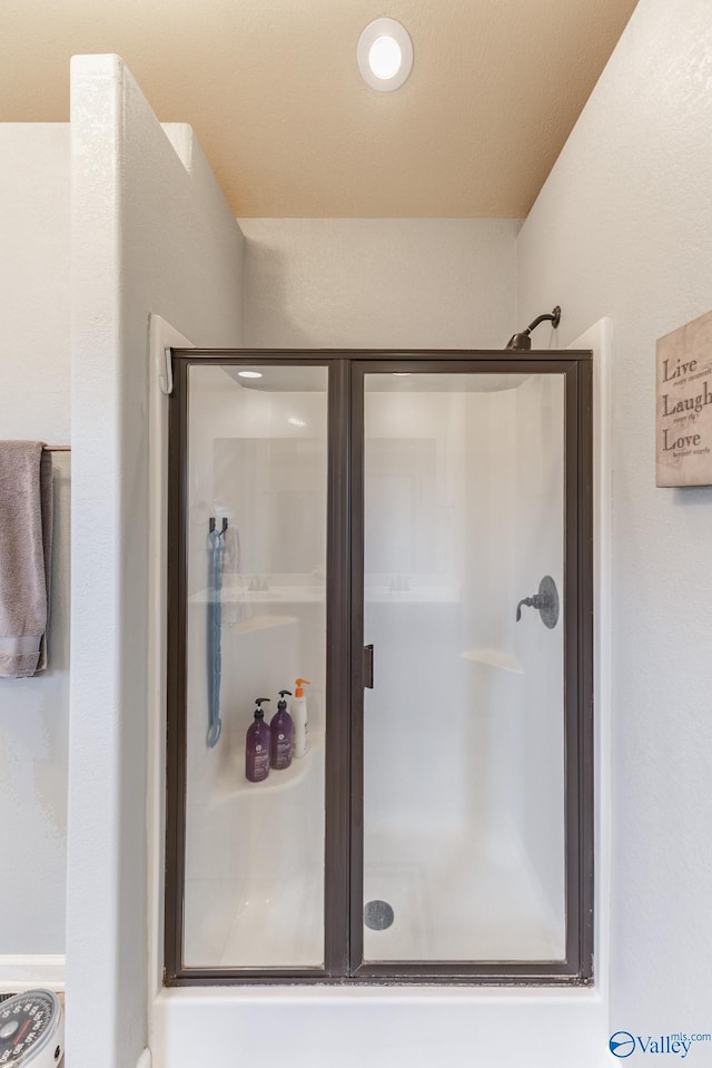 bathroom featuring a shower with shower door