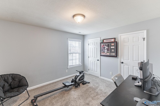 exercise area with carpet flooring and a textured ceiling