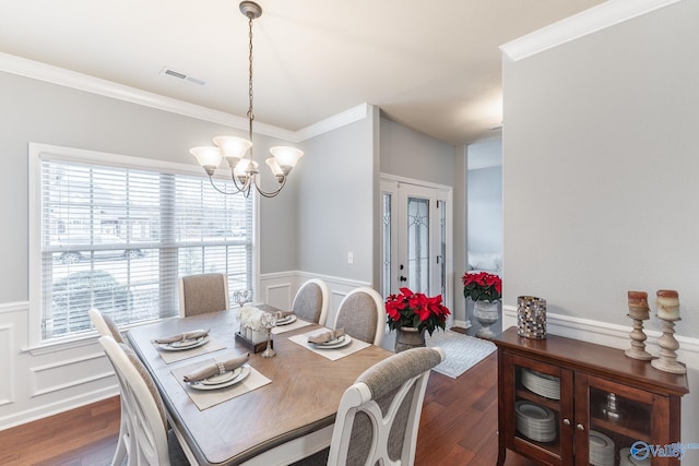 dining space featuring crown molding, dark hardwood / wood-style flooring, and a notable chandelier