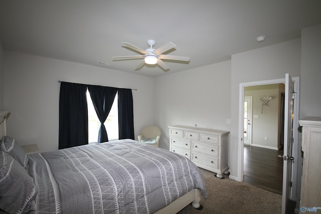 bedroom featuring baseboards, multiple windows, a ceiling fan, and dark carpet