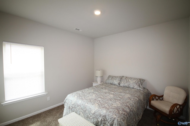 carpeted bedroom featuring baseboards and visible vents