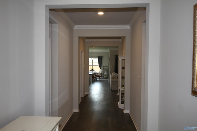 corridor with crown molding, dark wood-style flooring, and baseboards