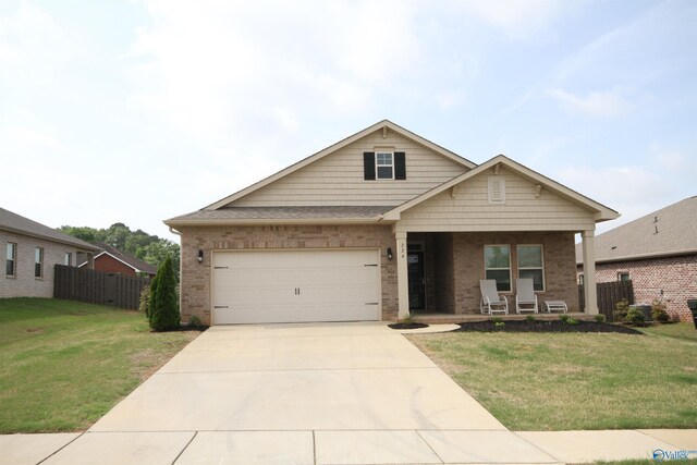 craftsman-style home featuring fence, brick siding, a porch, a front yard, and concrete driveway