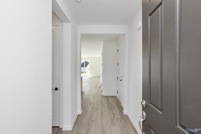 corridor with light hardwood / wood-style floors