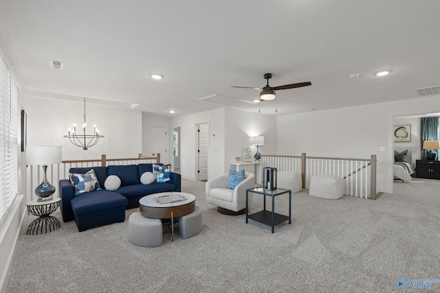 carpeted living room featuring recessed lighting, visible vents, and ceiling fan with notable chandelier