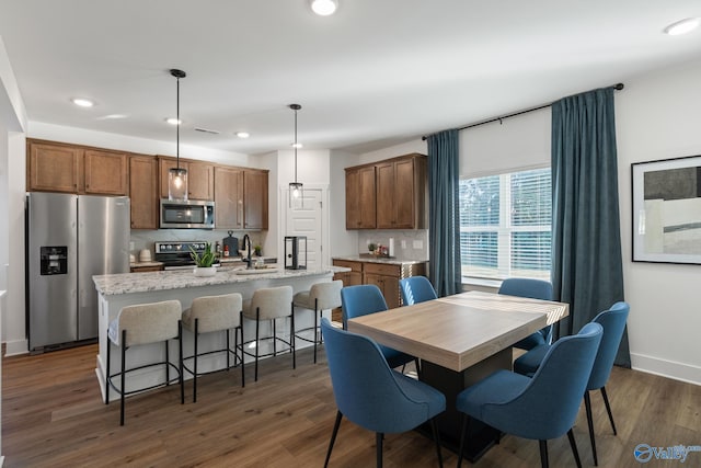 dining area featuring baseboards, dark wood finished floors, and recessed lighting