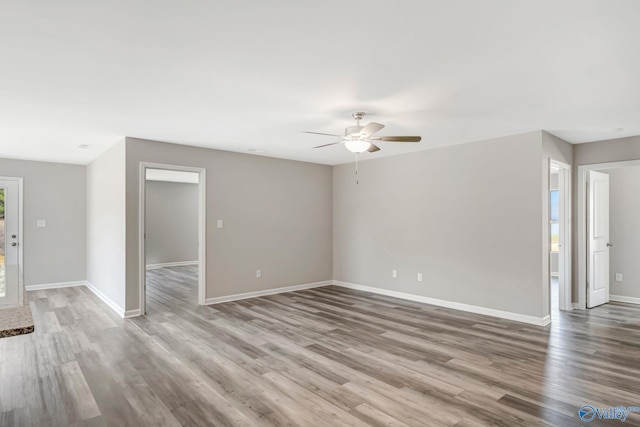 interior space featuring wood finished floors, baseboards, and ceiling fan