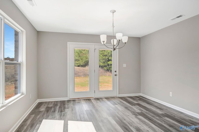 unfurnished dining area with visible vents, wood finished floors, and baseboards