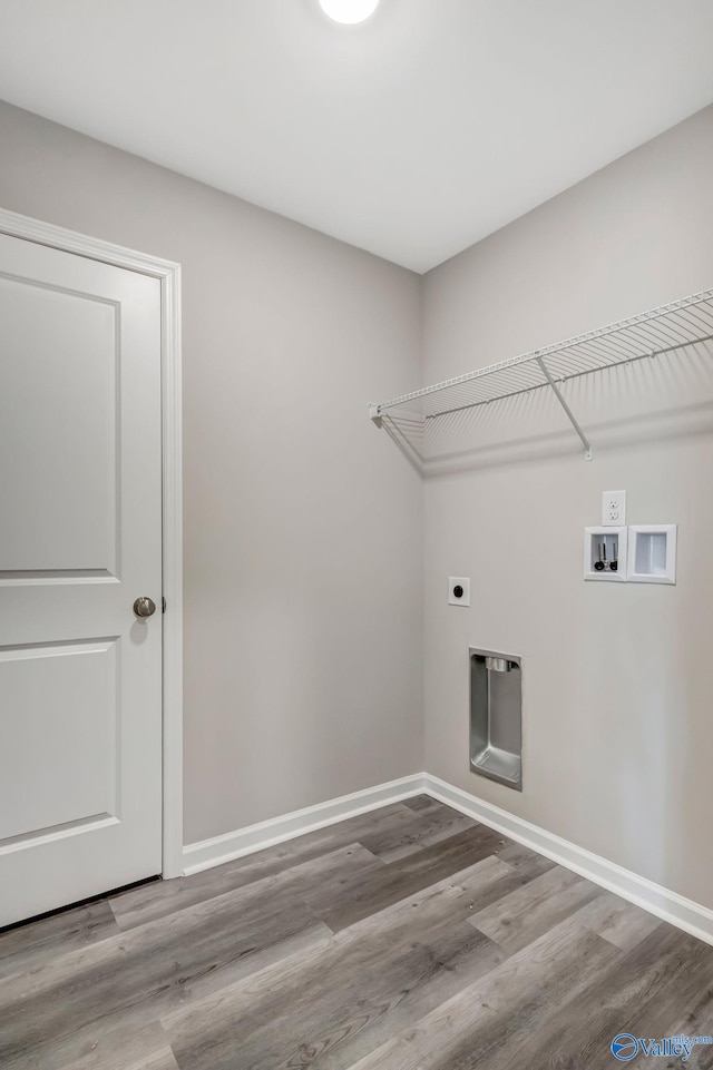 washroom with electric dryer hookup, baseboards, wood finished floors, and laundry area