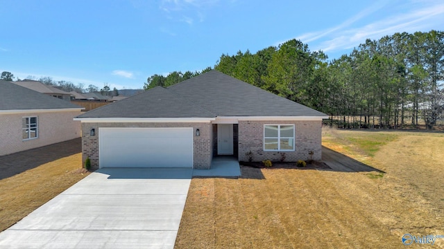 view of front facade featuring driveway, roof with shingles, a front yard, a garage, and brick siding