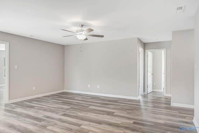 spare room featuring visible vents, baseboards, and wood finished floors