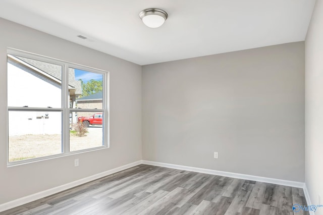 unfurnished room featuring baseboards and wood finished floors