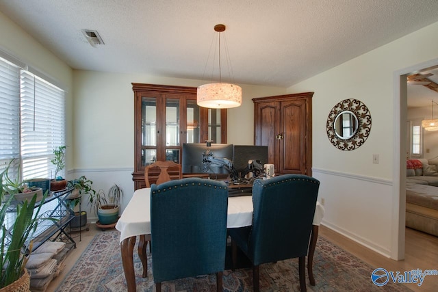 dining space with hardwood / wood-style floors and a textured ceiling