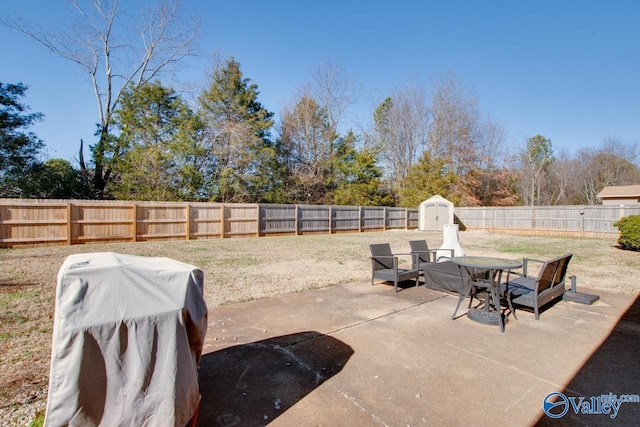 view of patio with area for grilling and a storage unit