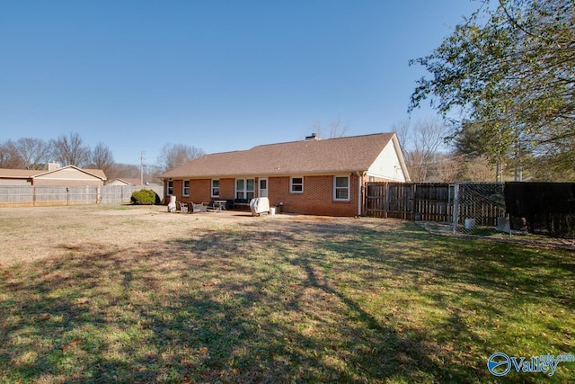 back of house featuring a patio and a lawn