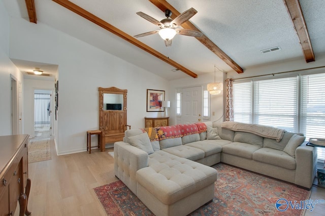 living room featuring high vaulted ceiling, light wood-type flooring, ceiling fan, a textured ceiling, and beam ceiling