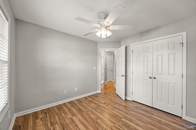 unfurnished bedroom featuring a closet, light wood-type flooring, and ceiling fan