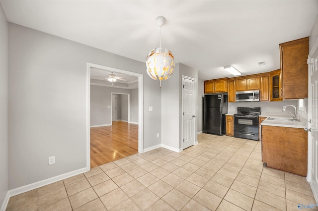 kitchen featuring ceiling fan, sink, decorative light fixtures, black appliances, and light wood-type flooring