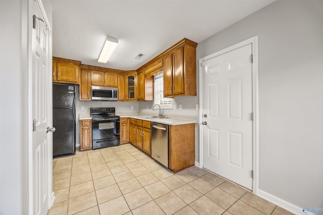 kitchen with black appliances, a textured ceiling, light tile patterned floors, and sink