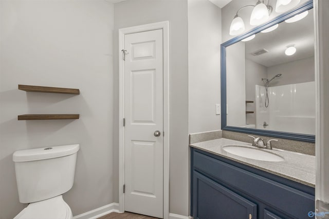 bathroom featuring walk in shower, vanity, and toilet