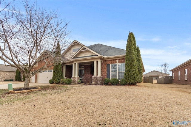 craftsman inspired home featuring a garage and a front lawn